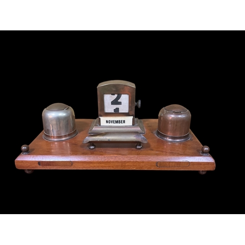 479 - A VINTAGE MAHOGANY BRASS AND PLATED DESK STAND with adjustable calendar, inkwells and pen rest 14cm ... 