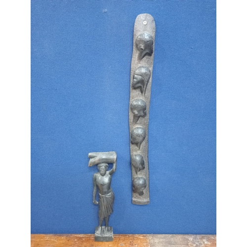 642 - TWO AFRICAN HARDWOOD CARVED FIGURES modelled as a female shown standing holding a log on her head, a... 