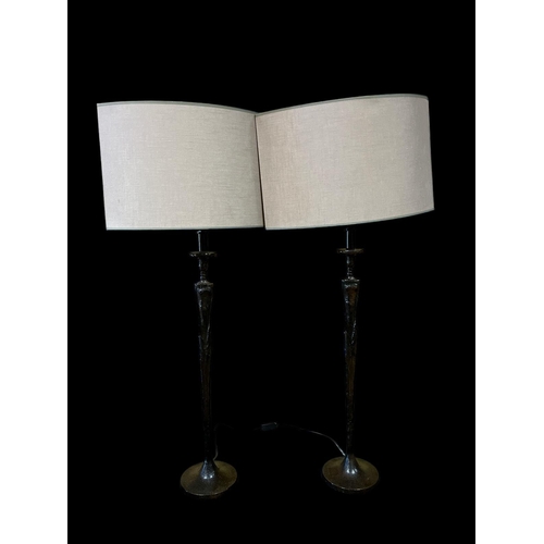 118 - A PAIR OF COMPOSITION TABLE LAMPS of irregular outline the shaped column above a circular spreading ... 