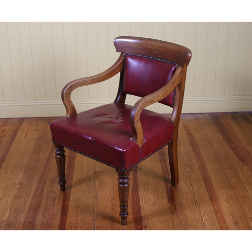 12 - A 19TH CENTURY OAK AND UPHOLSTERED LIBRARY ARMCHAIR the curved top rail with upholstered panel and s... 