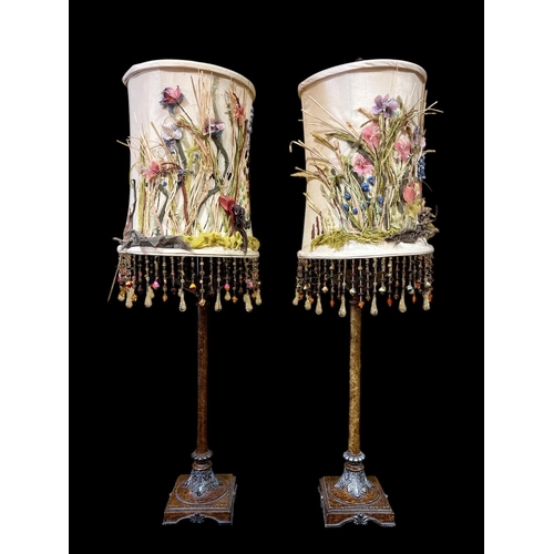 123 - A PAIR OF CONTINENTAL COMPOSITION TABLE LAMPS each with a cylindrical column raised on a square plat... 