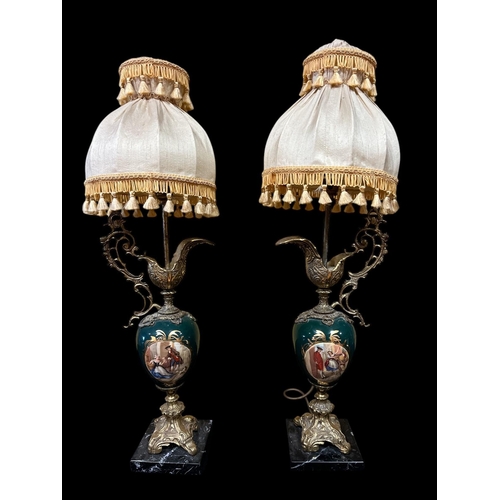 124 - A PAIR OF CONTINENTAL GILT METAL AND PORCELAIN URN SHAPED TABLE LAMPS raised on black veined marble ... 