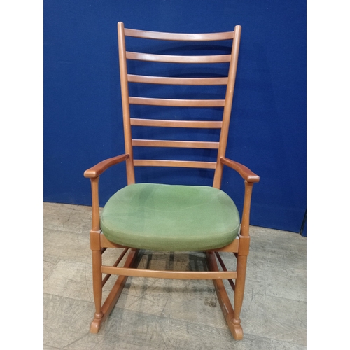 234 - A BEECH FRAME LADDER BACK ROCKING CHAIR with upholstered seat on moulded base