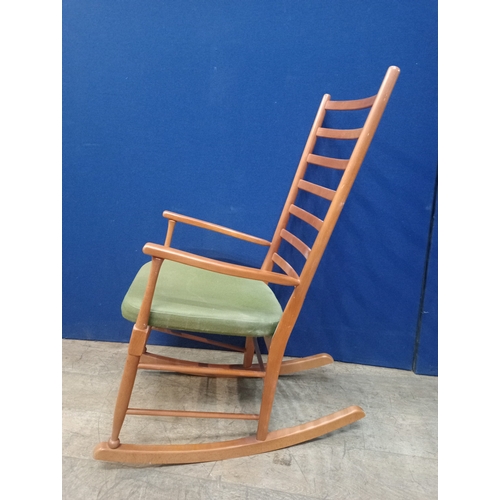 234 - A BEECH FRAME LADDER BACK ROCKING CHAIR with upholstered seat on moulded base