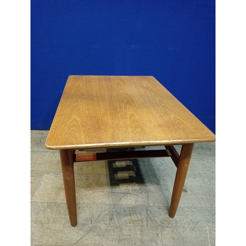 241 - A G-PLAN TEAK COFFEE TABLE of rectangular outline the shaped top on cylindrical tapering legs joined... 