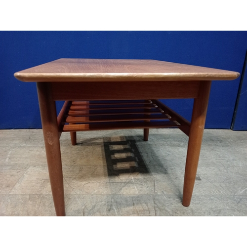 241 - A G-PLAN TEAK COFFEE TABLE of rectangular outline the shaped top on cylindrical tapering legs joined... 