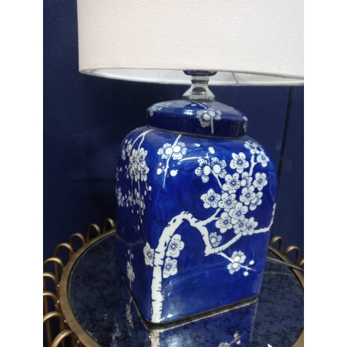 245 - A PAIR OF BLUE AND WHITE TABLE LAMPS each of square form the blue ground decorated with flowerheads ... 