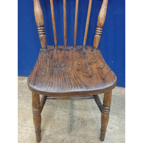 267 - AN ELMWOOD SPINDLE BACK SIDE CHAIR with shaped panelled seat on turned legs joined by cross stretche... 