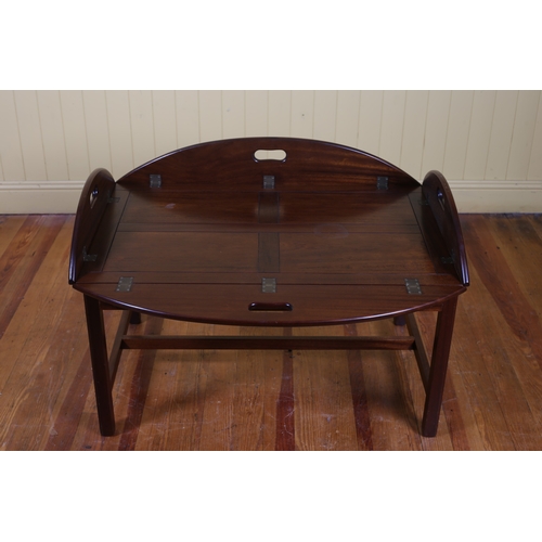 29 - A GEORGIAN STYLE MAHOGANY TRAY ON STAND of oval outline with hinged sides with carrying handles on m... 