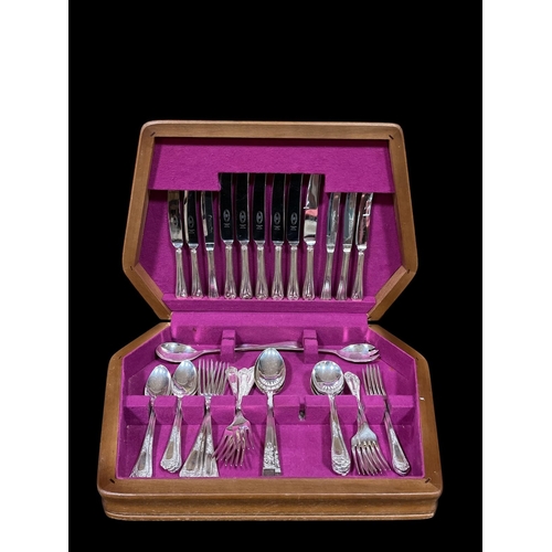 293 - A PART CANTEEN OF CUTLERY in teak case comprising dinner knives, table knives, servers, forks, etc.