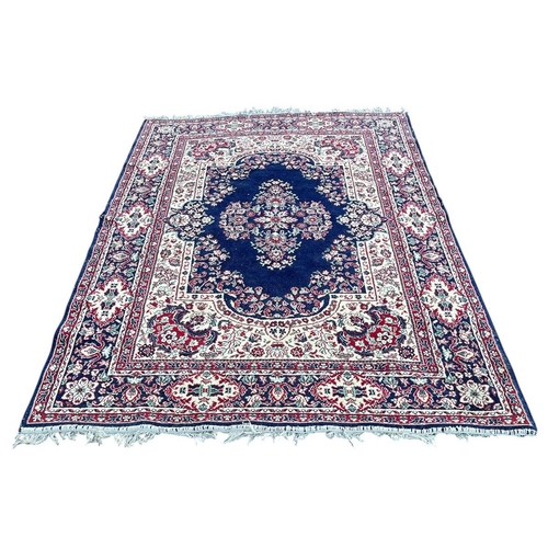 351 - AN ORIENTAL RUG the off white, indigo and red ground with central panel filled with stylised flowerh... 