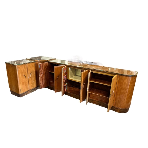 368 - AN ART DECO SATINWOOD SIDEBOARD of L-shaped outline with glazed tops above an arrangement of cupboar... 