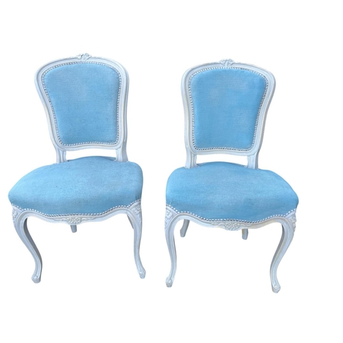 379 - A PAIR OF CONTINENTAL WHITE PAINTED AND UPHOLSTERED SIDE CHAIRS each with a foliate carved cresting ... 