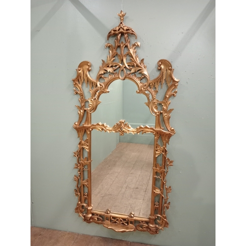 391 - A CONTINENTAL CARVED GILT FRAME MIRROR the rectangular arched plate within a pierced C-scroll flower... 