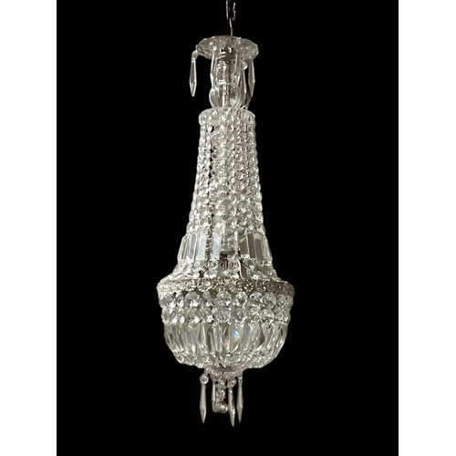 532 - A CONTINENTAL GILT BRASS AND CUT GLASS CENTRE LIGHT hung with cascading pedant drops above a basket ... 