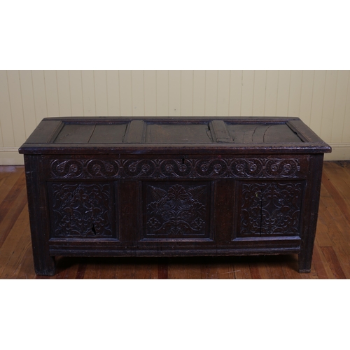 57 - AN EARLY CARVED OAK COFFER of rectangular outline the hinged lid with recessed panels above a carved... 