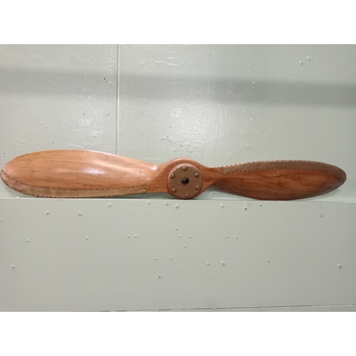 633 - A HARDWOOD AND BRASS BOUND PROPELLER of typical form 100cm (l)