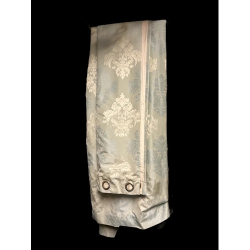 635 - A PAIR OF BLUE AND SILVERED FLORAL CURTAINS lined with eyelet rings 297cm drop x 270cm (w)