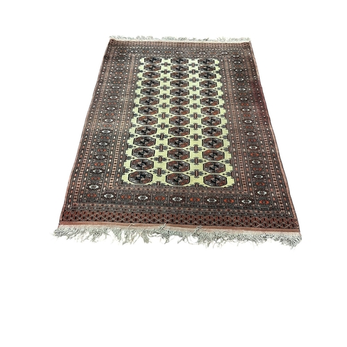 182 - A BOKHARA WOOL RUG the beige, light pink and multicolour ground with central panel filled with recta... 