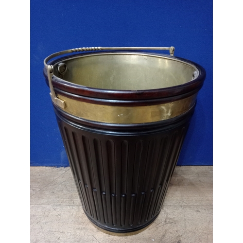 A GEORGIAN STYLE MAHOGANY AND BRASS BOUND PEAT BUCKET with roped swing handle above ribbed tapering frieze with gilt brass liner 67cm (h) x 50cm (d)