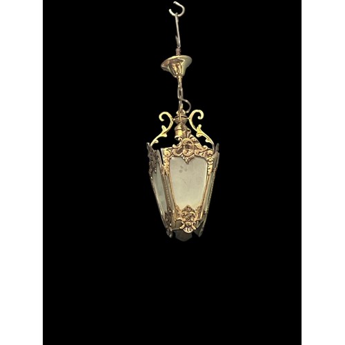 664 - A BRASS AND FROSTED GLASS SINGLE LIGHT HALL LANTERN the foliate cast frame with shaped frosted glass... 