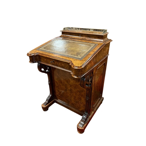 A FINE 19TH CENTURY BURR WALNUT DAVENPORT the superstructure with pierced brass gallery and hinged compartment containing pen trays above a tooled leather hinged writing slope containing four long drawers raised on pierced shaped supports and platform base flanked by a cupboard containing four long drawers with brass drop handles on bun feet 84cm (h) x 53cm (w) x 58cm (d)