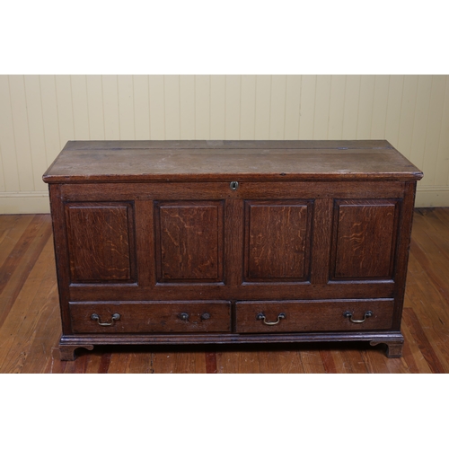 524 - AN EARLY OAK COFFER the rectangular hinged lid with panel frieze and two long drawers with brass dro... 