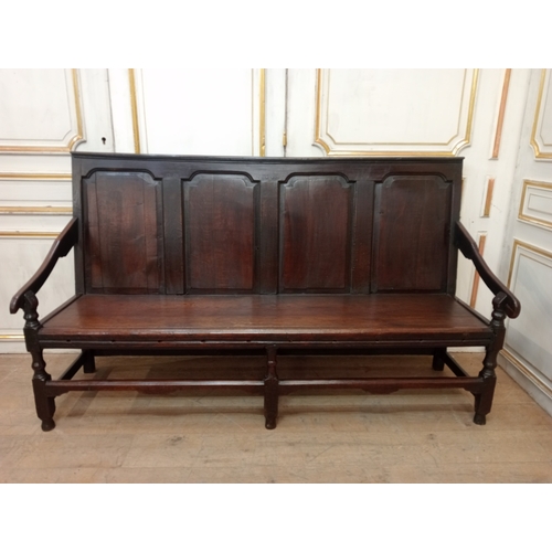 409 - AN EARLY OAK BENCH with panelled back and seat and scroll arms on moulded legs 107cm (h) x 187cm (w)... 