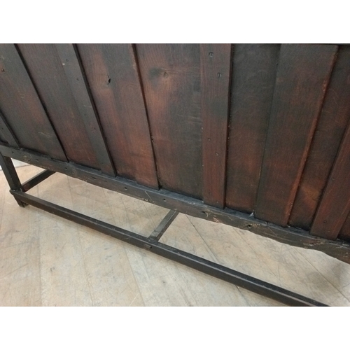 409 - AN EARLY OAK BENCH with panelled back and seat and scroll arms on moulded legs 107cm (h) x 187cm (w)... 