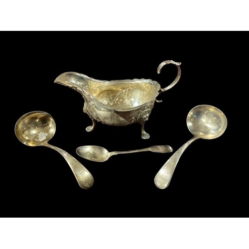 AN IRISH SILVER EMBOSSED SAUCE BOAT Dublin 1977 10 troy oz, two silver ladles Sheffield together with a silver teaspoon (4)
