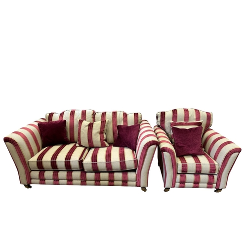 A VICTORIAN STYLE TWO SEATER SETTEE with scroll over arms and loose cushions on brass caps and castors 180cm (w) together with AN ARMCHAIR en suite