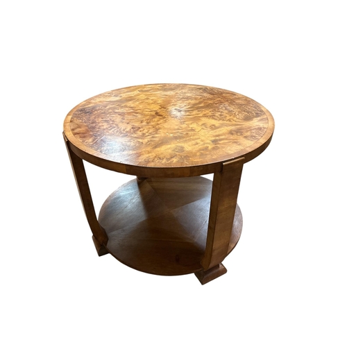 358 - A VINTAGE WALNUT CROSSBANDED COFFEE TABLE of circular outline on shaped supports with block feet joi... 