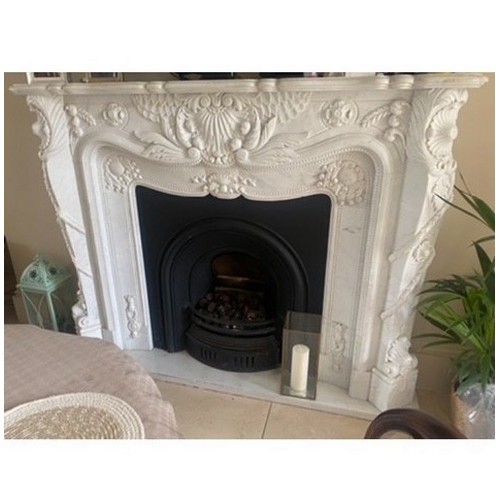 386 - A WHITE MARBLE CHIMNEY PIECE the serpentine shelf above a foliate carved frieze with conforming jamb... 