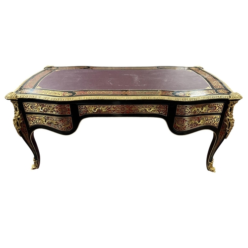 A CONTINENTAL RED BOULLE EBONISED AND BRASS INLAID BUREAU PLAT of serpentine outline the shaped top with one long and four short drawers on cabriole legs with gilt brass sabots and mounts 81cm (h) x 184cm (w) x 92cm (d)