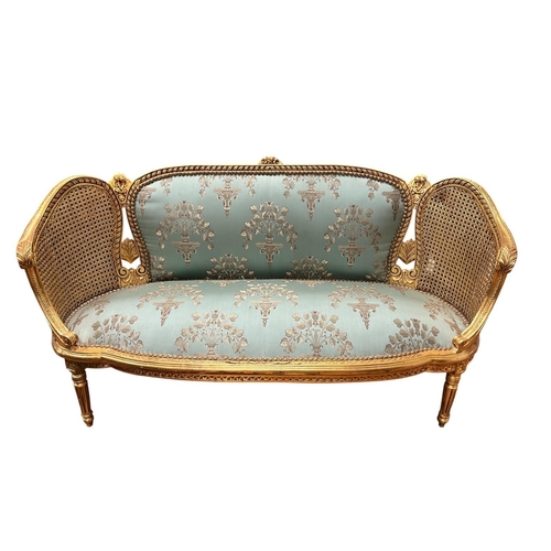 76 - A CONTINENTAL CARVED GILTWOOD AND UPHOLSTERED SETTEE the flowerhead cresting above an upholstered pa... 