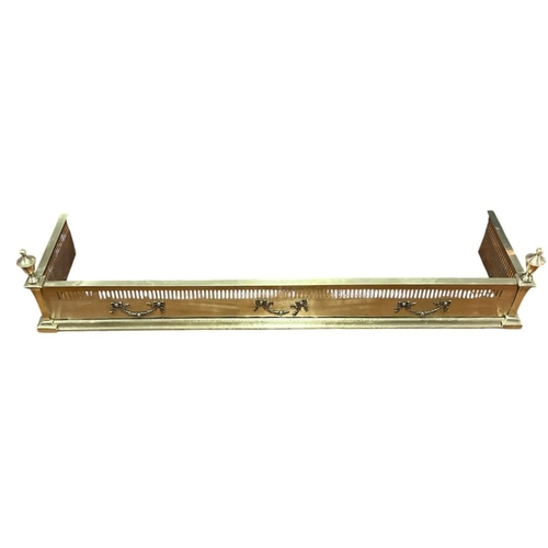 84 - A VINTAGE PIERCED BRASS FENDER with urn finials on stepped platform base 26cm (h) 128cm (d) 33cm (d)