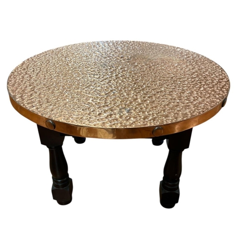 92 - A VINTAGE STAINED WOOD AND HAMMERED COPPER OCCASIONAL TABLE of circular outline on baluster legs 36c... 