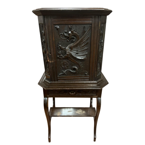 64 - A VINTAGE HARDWOOD SIDE CABINET of rectangular outline with canted angles the shaped top above a gar... 