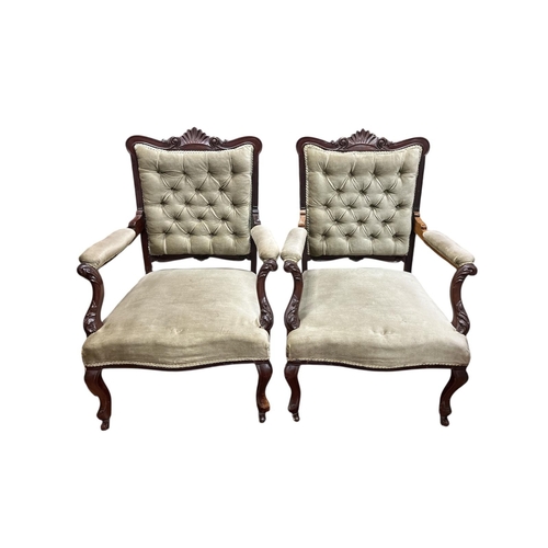 67 - A PAIR OF EDWARDIAN CARVED MAHOGANY AND UPHOLSTERED ARMCHAIRS each with a shell and foliate carved t... 