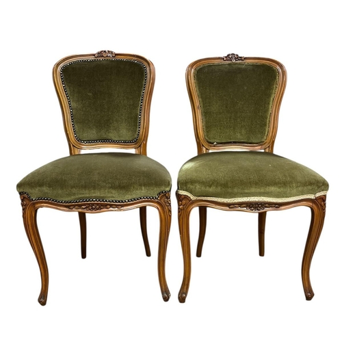 117 - A PAIR OF CONTINENTAL STAINED WOOD AND UPHOLSTERED SIDE CHAIRS each with a foliate carved cresting w... 