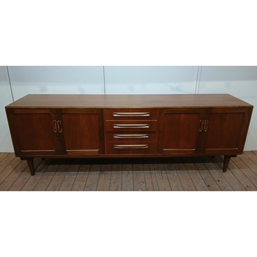 279 - A VINTAGE G-PLAN TEAK SIDEBOARD of rectangular outline the shaped top above four frieze drawers and ... 