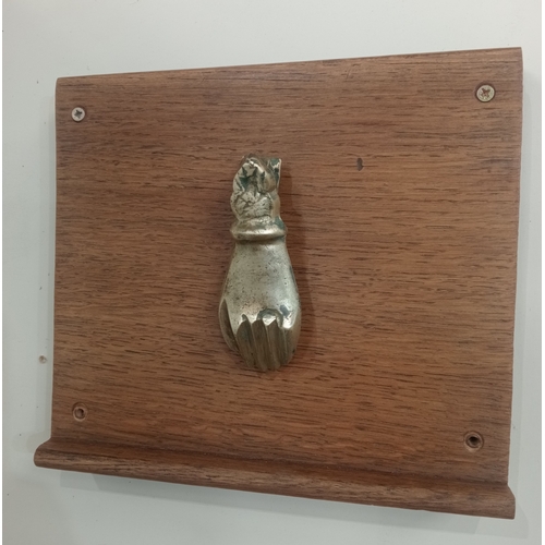 616 - A GILT BRASS DOOR KNOCKER in the form of a hand mounted on a hardwood plaque 21cm (h) x 24cm (w)