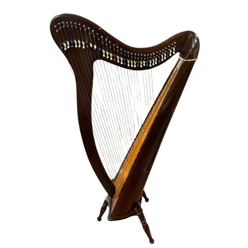 528 - A THIRTY-FOUR STRING STAINED WOOD HARP with spruce sound board raised on three baluster legs 140cm (... 