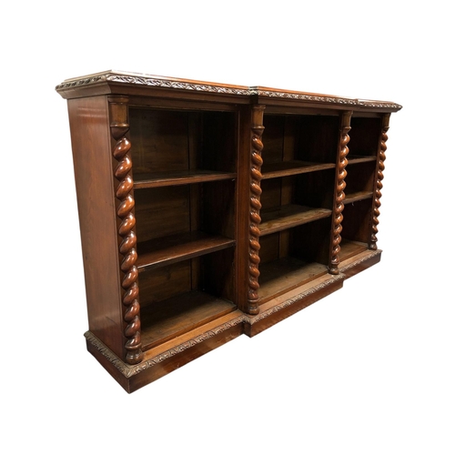 A 19TH CENTURY CARVED MAHOGANY OPEN FRONT BOOKCASE of breakfront outline the shaped top above nine open shelves, six adjustable, between spiral twist pilasters on platform support 111cm (h) x 206cm (w) x 43cm (d)