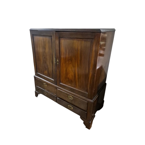 390 - A GEORGIAN MAHOGANY LINEN CUPBOARD of rectangular outline the shaped top above a pair of cupboards c... 