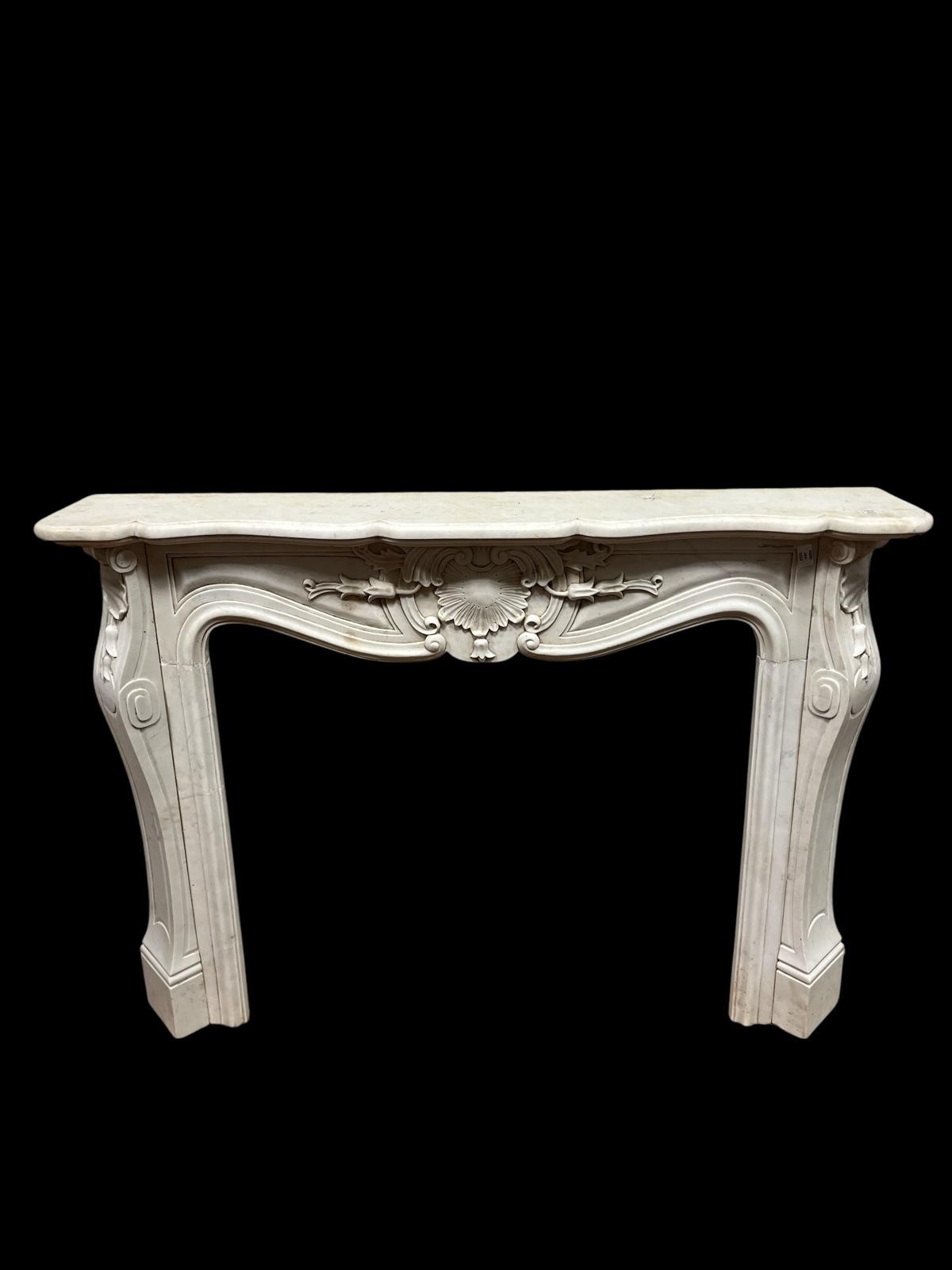 A CONTINENTAL WHITE MARBLE CHIMNEY PIECE the serpentine shelf above a ...