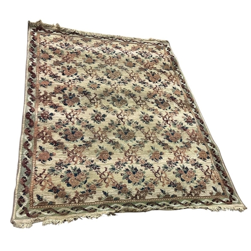 146 - A BEIGE, LIGHT GREEN AND MAROON PATTERN RUG the central panel filled with stylised flowerheads and f... 