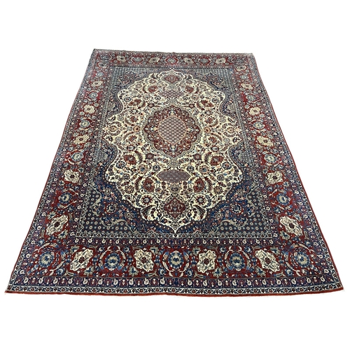 A FINE ORIENTAL WOOL RUG the wine, beige and indigo ground with central panel filled with palmettes, stylised flowerheads and foliage within a conforming border 435cm (l) x 299cm (w)