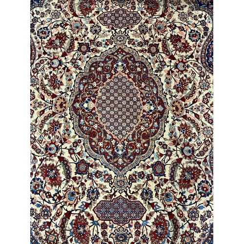 151 - A FINE ORIENTAL WOOL RUG the wine, beige and indigo ground with central panel filled with palmettes,... 