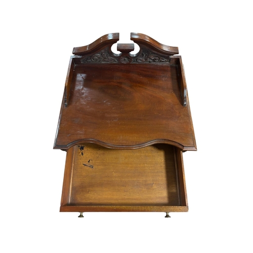 65 - AN EDWARDIAN MAHOGANY MUSIC STAND of serpentine outline the shaped top with carved and moulded three... 